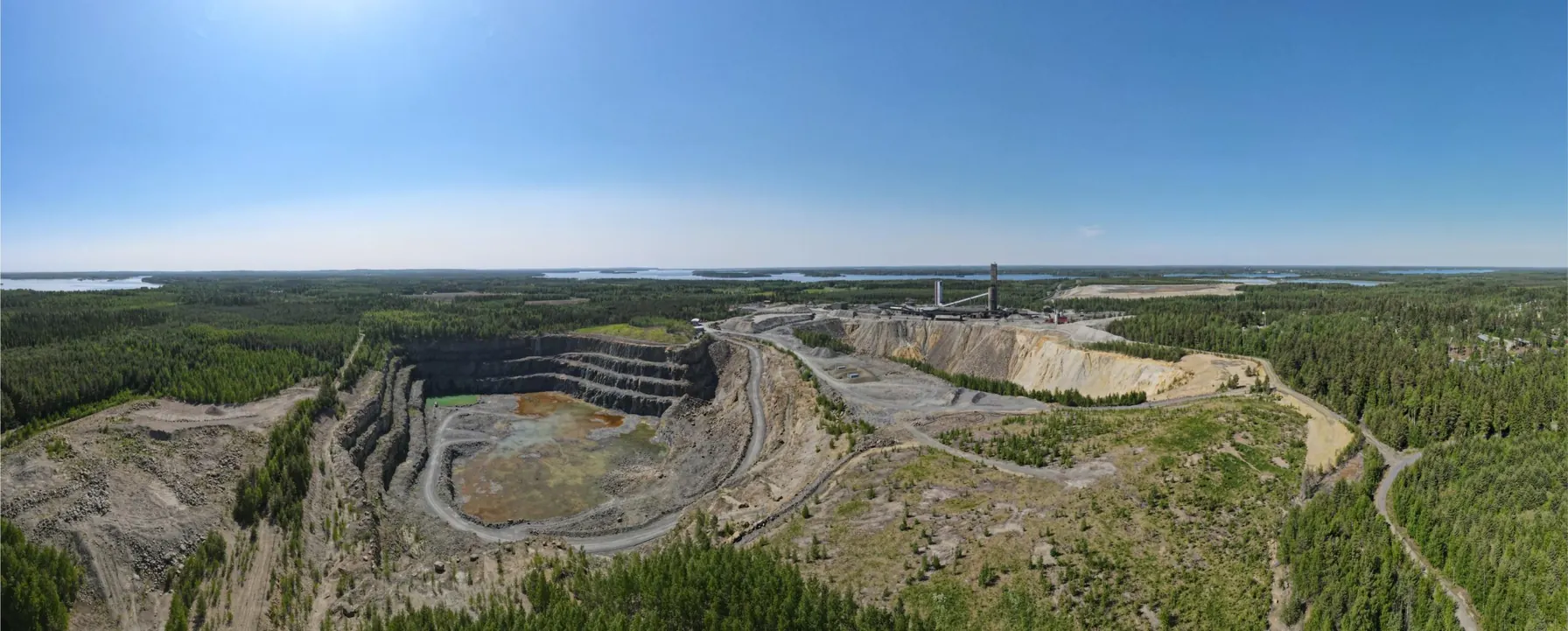 Ilmakuva Pyhäsalmen kaivosalueesta: avolouhos, rikastamo ja ympäröivät järvimaisemat